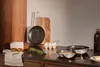 A kitchen counter with cooking utensils, ingredients, and a cutting board. Náhled obrázku produktu