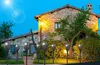 Solar torch lights illuminating a stone house and garden at dusk. Voir les images du produit
