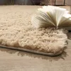 A close-up of a beige, high-pile rug with an open book resting on it. Produktbild-Vorschau