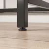 Close-up of the leg of a table or desk with an adjustable foot on a wooden floor. Podgląd zdjęcia produktu