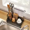 A kitchen sink organizer with various cleaning tools and utensils. Voir les images du produit
