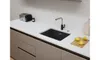 A modern kitchen countertop with a black sink, faucet, toaster, and lemons on a cutting board. Podgląd zdjęcia produktu
