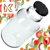 A clear glass jar with a black lid, surrounded by various fresh vegetables and herbs. Podgląd zdjęcia produktu