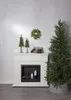 A Christmas tree and fireplace scene with decorative trees and gifts. Produktbild-Vorschau