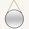 A round mirror with a rope hanger against a light gray background. Produktbild-Vorschau