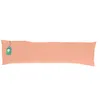 A long, peach-colored body pillow is laid out horizontally on a white background. A small, green tag is attached to the left end of the pillow. Produktbild-Vorschau