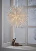 A large white paper star decoration hangs in a window with a snowy scene outside. Cinnamon sticks and twine are on the windowsill below. Podgląd zdjęcia produktu