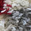 A close-up view of a shaggy rug with red, white, and gray fibers. Produktbild-Vorschau