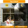 A split image showing a solar light on a wall, with the left side depicting daytime and the right side depicting nighttime. Two people are sitting at a table outside a house, with the left side of the image brighter and the right side darker. Produktbild-Vorschau
