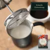 A close-up of a manual milk frother with a cup of coffee and a small e-book cover in the background. Produktbild-Vorschau