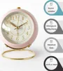 A pink alarm clock with gold accents is shown on a white background, with marketing text overlays on the right side. Produktbild-Vorschau