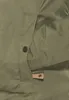 Close-up of a green jacket pocket with a button and a leather tag. Produktbild-Vorschau