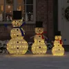 Three illuminated snowmen of varying sizes are displayed outdoors in the snow, in front of a brick building with a window. Náhled obrázku produktu