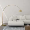 A modern living room with a white sectional sofa and a gold arc floor lamp. Náhled obrázku produktu