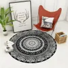 A round mandala rug is placed on the floor next to a red butterfly chair, a framed picture, and a potted plant. Produktbild-Vorschau