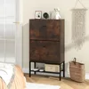 A shoe cabinet with two drawers and shelves is placed in a room next to a bed and a door. Podgląd zdjęcia produktu