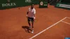 A male tennis player on a clay court preparing to serve. Produktbild-Vorschau