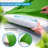 A person is demonstrating how to put a pillow into a green pillowcase, which is part of a sleeping bag. Produktbild-Vorschau