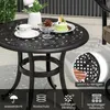 A round table set on a patio with a cup, a small cake, and a vase of flowers. Podgląd zdjęcia produktu