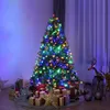 A decorated Christmas tree with presents underneath, illuminated by colorful lights. Produktbild-Vorschau