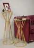 Two gold accent tables are shown next to a burgundy sofa. One table holds a framed picture, and the other holds a decorative bowl. Produktbild-Vorschau