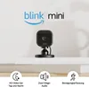 A Blink Mini smart camera is displayed on a shelf, with feature icons and text below. Podgląd zdjęcia produktu