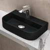 A black ceramic washbasin with a chrome faucet is placed on a marble countertop. Produktbild-Vorschau