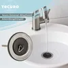 A close-up of a sink drain stopper and a faucet with water running into a sink. Produktbild-Vorschau