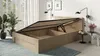 A modern bedroom with a wooden bed frame with its storage compartment open, showcasing the slatted base and storage space. Two potted plants are visible on the left, and wall-mounted lamps are on the right. Produktbild-Vorschau