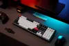 A gaming setup with a keyboard, mouse, controller, and a digital clock. Produktbild-Vorschau