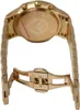 The back of a gold-colored watch with its clasp open. Produktbild-Vorschau