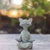 A gray cat figurine meditating outdoors. Produktbild-Vorschau