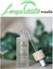 A bottle of anti-aging serum with a dropper, with greenery in the background. Anteprima dell’immagine prodotto