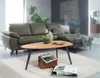 A living room scene featuring a green sectional sofa and a wooden coffee table. Voir les images du produit
