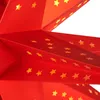 A close-up view of a red paper star lantern with yellow star cutouts. Náhled obrázku produktu