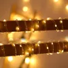 Close-up of LED string lights wrapped around wooden dowels, with blurred bokeh lights in the background. Produktbild-Vorschau