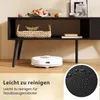 A robot vacuum cleaner is shown on a wooden floor in front of a black media console. The console has a basket and some fruit on top, and books on a shelf. A circular inset shows a close-up of water droplets on a black surface. Produktbild-Vorschau