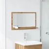 A bathroom mirror with a shelf above a sink and faucet. Voir les images du produit