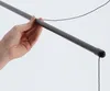 A hand holding a gray drying rod with a black string attached. Produktbild-Vorschau