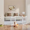 A white wooden dog gate is set up in a living room in front of a sofa, with a corgi dog sitting in front of it. Podgląd zdjęcia produktu