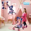 A young girl in a pink dress stands next to a doll stroller in a pink room with a teepee. Produktbild-Vorschau