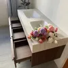 A double sink vanity with open drawers and a bouquet of flowers on top. Anteprima dell’immagine prodotto