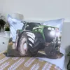 A pillow with a tractor image is placed on a bed with patterned bedding. Náhled obrázku produktu