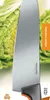 A close-up of a Fiskars kitchen knife with a green leafy vegetable in the background. Podgląd zdjęcia produktu