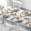 A dining table set for a meal with plates, bowls, cutlery, and food. Náhled obrázku produktu