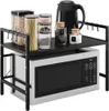 A black metal microwave stand with a microwave on the bottom shelf and various kitchen items on the top shelf. Náhľad obrázku produktu