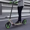 A person riding a scooter on a street. Náhled obrázku produktu
