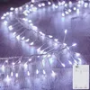 A string of white LED lights with a copper wire base is laid out on a wooden surface. Produktbild-Vorschau