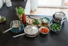 A kitchen counter with cooking ingredients and cookware laid out. Produktbild-Vorschau
