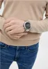 A person wearing a watch and jeans. Produktbild-Vorschau